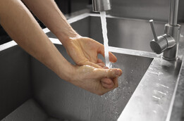 Personne se lavant les mains sous un robinet d'eau 